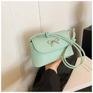 Close-up of mint green leather crossbody bag with a silver bow knot metal buckle