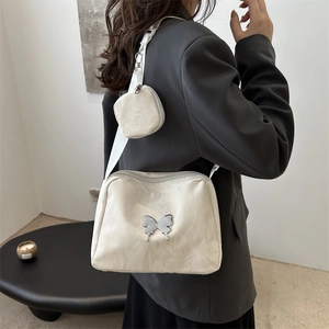 Chic beige crossbody bag set with butterfly hardware and a small coin purse on a strap