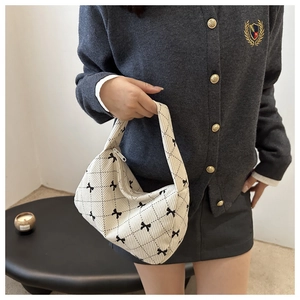 Détail du sac à main en velours côtelé avec motifs nœuds noirs et texture matelassée