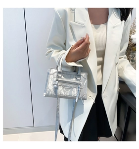 Detail of silver metallic textured handbag with fringes and motorcycle style accents