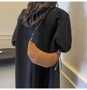 Detailansicht der Halbmond-Tasche mit Leopardenmuster und geknotetem schwarzen Riemen