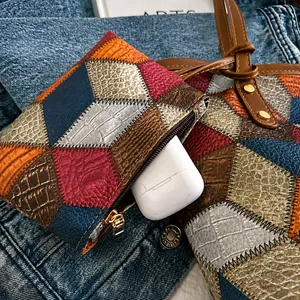 Dettaglio di ciondolo in pelle patchwork con motivi a rombi per auricolari