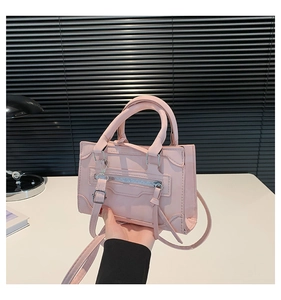 Pink synthetic leather handbag detail featuring top handles and silver decorative zippers