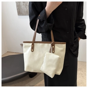 Dettaglio della grande borsa tote crema con manici marroni e pelle testurizzata