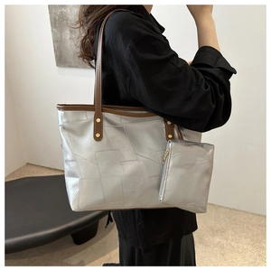 Dettaglio della borsa tote geometrica argento con tracolla in pelle marrone e pochette