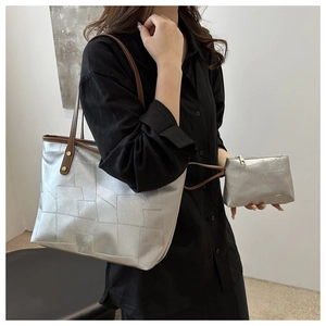 Dettaglio della borsa tote argento con trama geometrica e astuccio coordinato