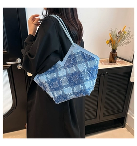 Détail des bords effilochés et du patchwork de denim sur un sac cabas élégant