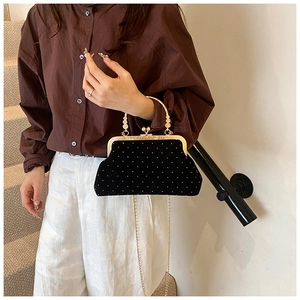 Polka dot black velvet shell bag with gold metal handle and chain shoulder strap