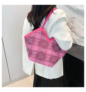 Close-up of pink and purple tweed tote bag with fringe details on white blazer