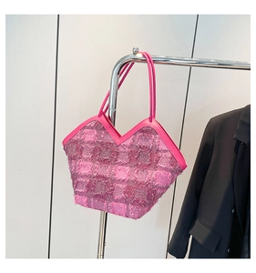 Detailed macro view of pink tweed bucket bag with fringe texture and V-shaped leather handle
