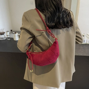 Rote Croissant-Tasche aus Wildleder mit verstellbarem Riemen von einem Model getragen