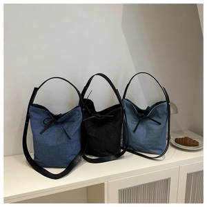 Trois sacs seaux en denim avec nœuds élégants sur des étagères épurées