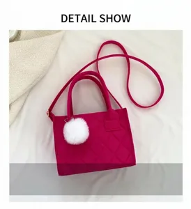 Nahaufnahme der rosaroten gesteppten Tasche mit Plüschbommel und Stoffstruktur-Details
