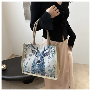 Modische Leinen-Tragetasche mit blauem Elch-Druck am Model getragen für den Alltag