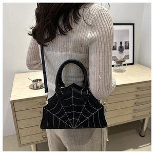 Detail of black spider web handbag with white contrast stitching and matte leather texture