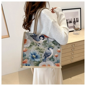 Detailansicht einer Canvas-Tragetasche mit Blumenmuster und Vogelmotiven im Alltagsszenario