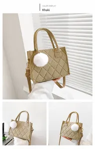 Detail der khakifarbenen gesteppten Tweed-Tasche mit weißem Bommel und Schultergurt