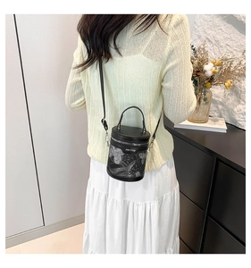 Detail of black cylindrical bucket bag with silver feather embroidery and zipper
