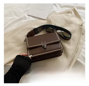 Brown oil wax leather handbag featuring metal H-buckle and ethnic wide shoulder strap