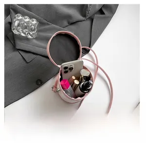 Vue détaillée montrant la capacité intérieure du mini sac seau cylindrique rose avec un mobile