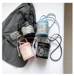 Close-up of four stylish textured bucket bags in various colors with leather handles