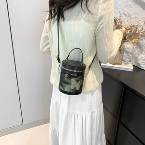 Chic black bucket bag with green butterfly embroidery and stylish top handle design