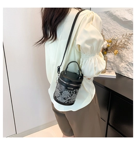 Detailed view of black bucket bag featuring intricate silver embroidery and zip closure