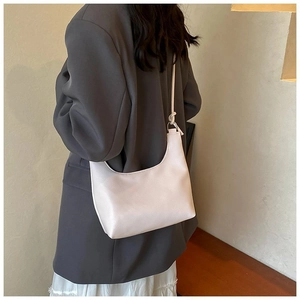 Bolso de hombro blanco minimalista en cuero combinado con chaqueta gris moderna