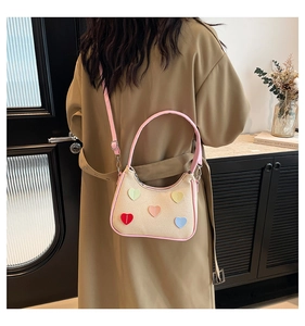 Détail du sac sous l'aisselle en toile avec cœurs colorés et bandoulière rose