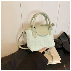 Detail of mint green quilted crossbody bag with stylish faux leather flap and top handle
