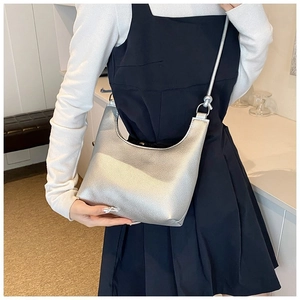Bolso hobo plateado con textura granulada y acabado metálico llevado al hombro
