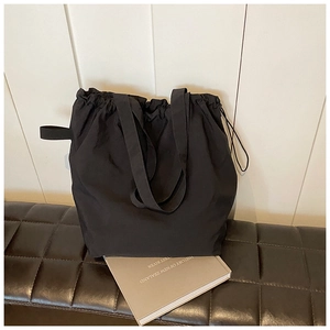 Dettaglio della borsa a secchiello in nylon nero con trama del tessuto resistente