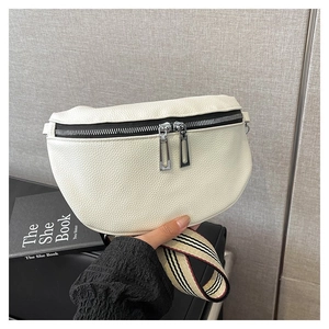 Détail du sac banane blanc cassé texture lychee avec bandoulière rayée et zips noirs