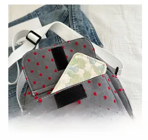 Detailed interior of a grey canvas polka dot bag showing capacity with a mobile phone