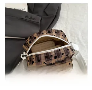 Internal view of brown checkered crossbody bag showing interior capacity and heart print