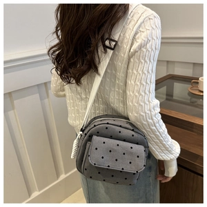 Rear view of a model wearing the casual grey polka dot canvas crossbody shell bag