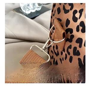 Detail showing high-quality metal hooks and leopard print canvas strap of the tote bag