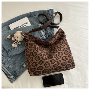 Detail of leopard print bucket bag with adjustable strap and cute plush cat charm