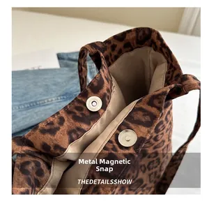 Dettaglio della borsa tote in tela leopardata con chiusura a scatto magnetico