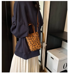 Close-up of stylish leopard print mini tote bag with adjustable brown shoulder strap