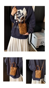 Detailed view of mini leopard print tote bag with brown handles and crossbody strap