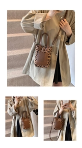 Detail shot of leopard print mini crossbody bag with leather trim on model