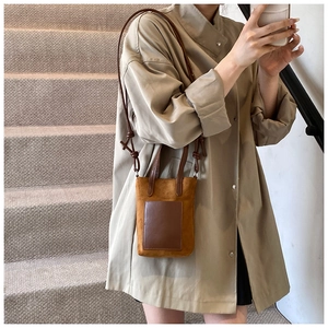 Close-up of minimalist mini crossbody phone bag in retro brown suede and leather texture