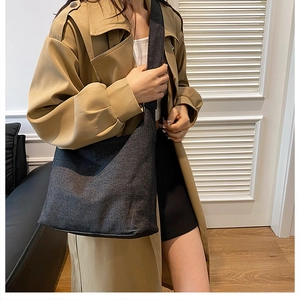 Détail du cabas en denim gris foncé texturé porté avec un trench décontracté