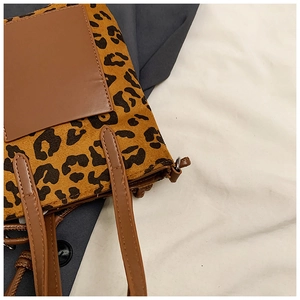 Detail of leopard print fabric and brown leather pocket on a retro crossbody bag