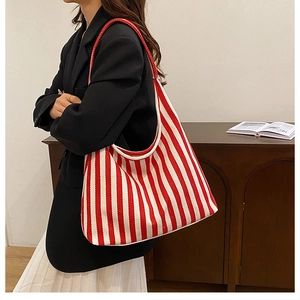 Vista lateral del gran bolso tote de lona con rayas verticales rojas y blancas