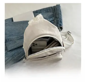 Detail showing the internal storage capacity for phone and wallet in white soft bag