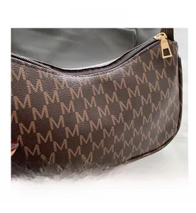 Detailed macro of vintage brown monogram shoulder bag featuring smooth golden zipper closure