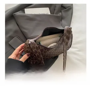 Detail view of the brown crescent bag interior capacity showing phone and wallet