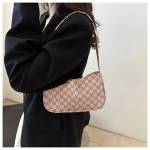 Detail of trendy crescent underarm bag with M-letter monogram print on shoulder